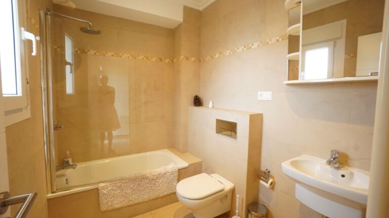 Bathroom with shower, vanity, and modern fittings inside a villa near La Fustera beach.