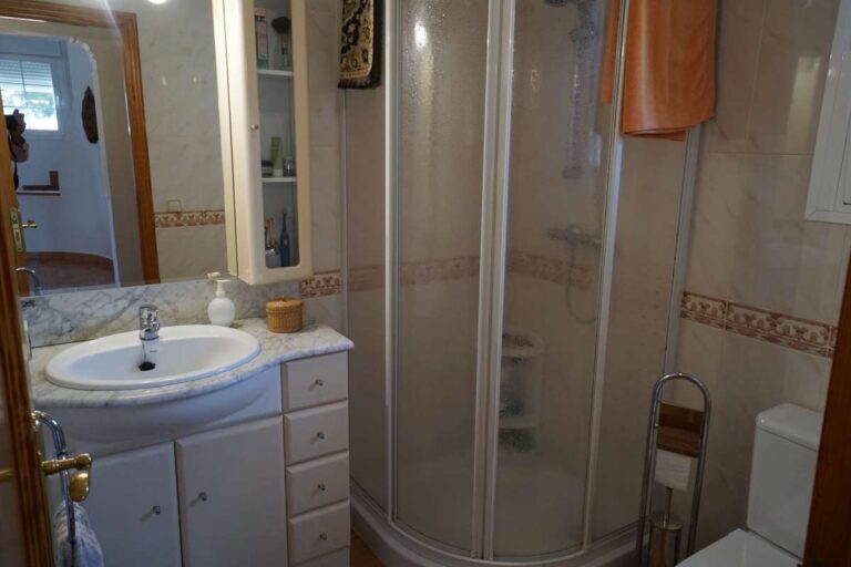 Bathroom with shower, vanity and natural light inside a Mediterranean villa near La Calalga Beach in Calpe.