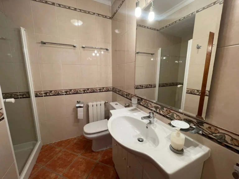 Bathroom with shower, vanity unit, toilet, radiator, and mirror inside a villa in Calpe.