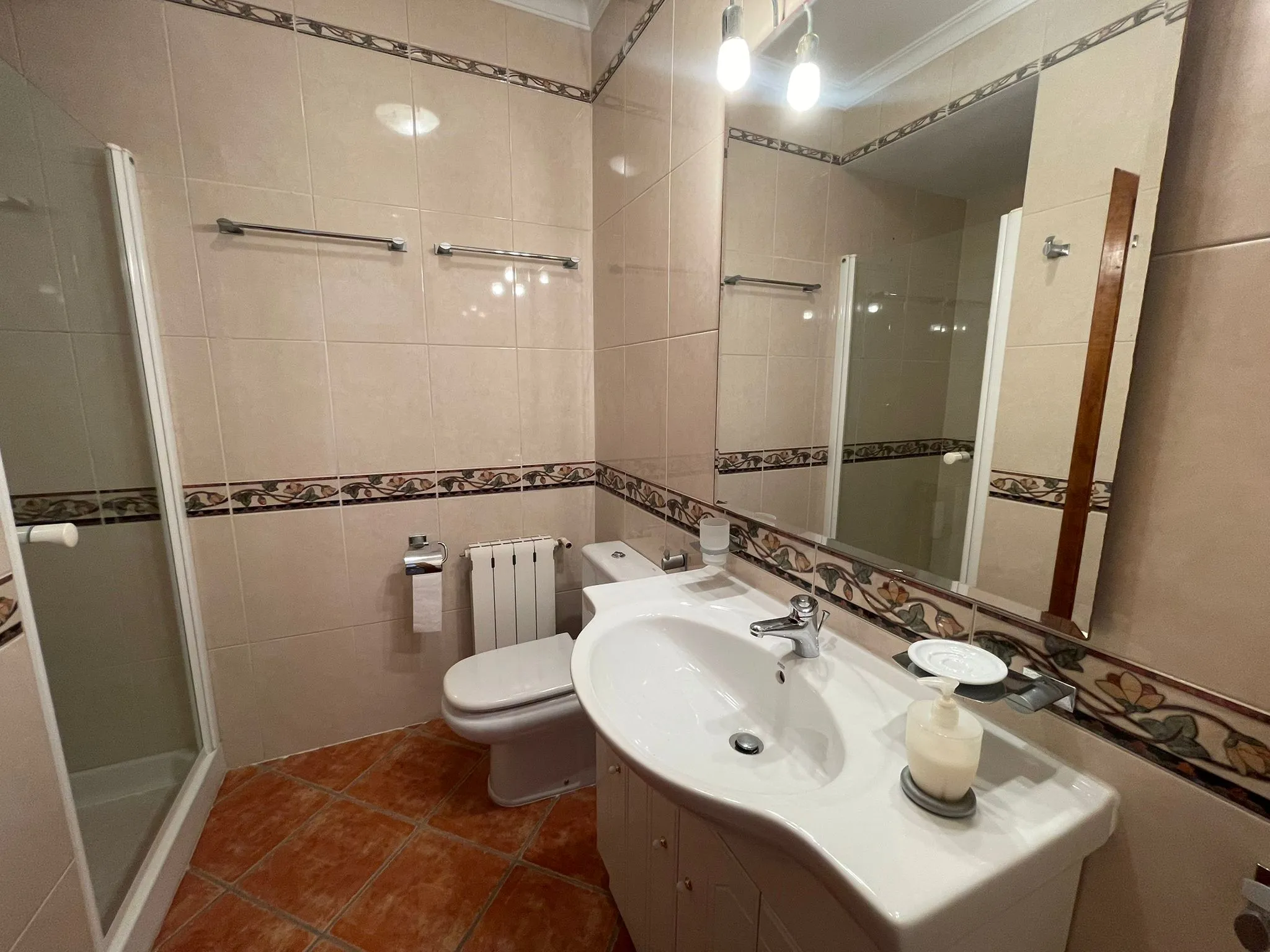 Bathroom with shower, vanity unit, toilet, radiator, and mirror inside a villa in Calpe.
