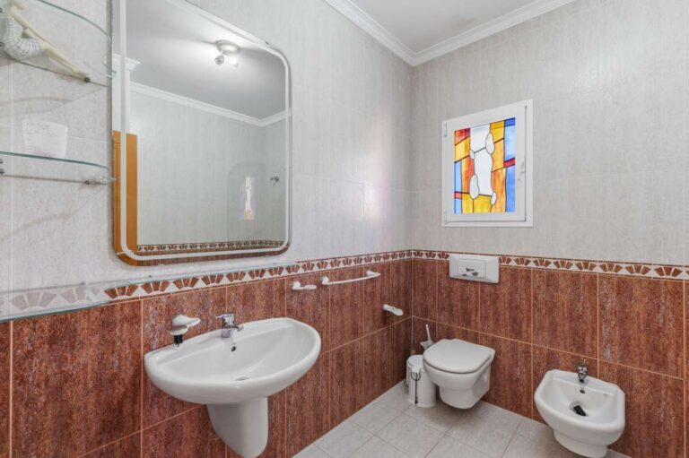 Bathroom with sink, toilet, bidet, and natural light inside a villa in Calpe.