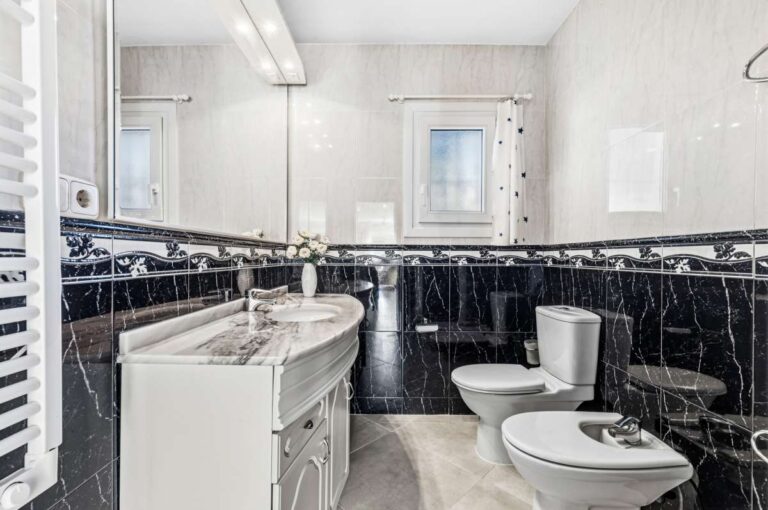 Bathroom with vanity, bath and black tile detailing inside a contemporary villa in Calpe.