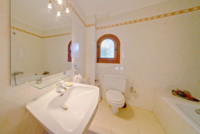 Bathroom with vanity, bath, toilet and natural light inside a second line Mediterranean villa near Puerto Blanco in Calpe.