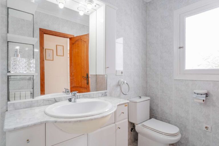 Bathroom with vanity, toilet and natural light inside a Mediterranean villa in Calpe.