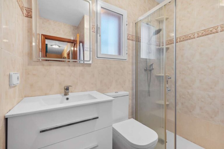 Bathroom with vanity, toilet and walk-in shower inside a single-level villa in Calpe close to beaches and amenities.