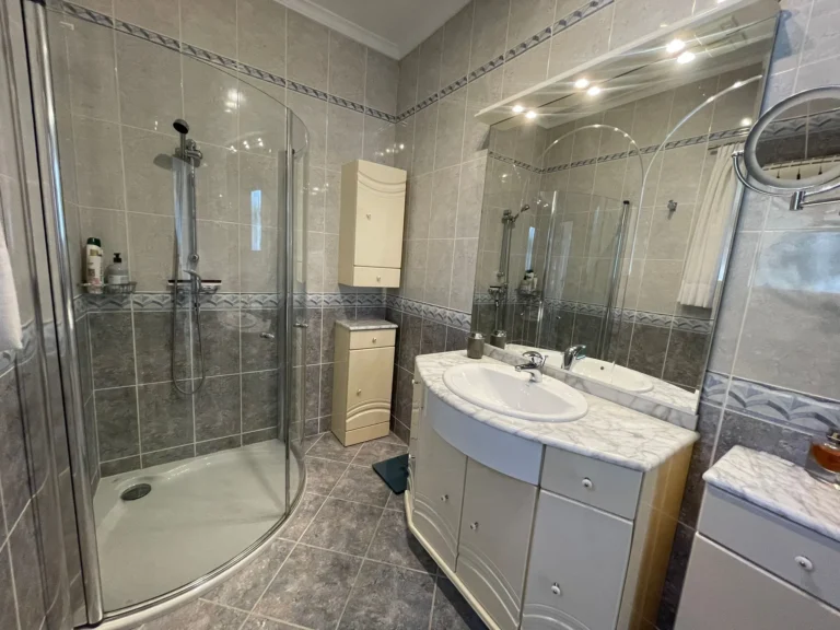 Bathroom with walk-in shower and fitted vanity inside a villa in Calpe.
