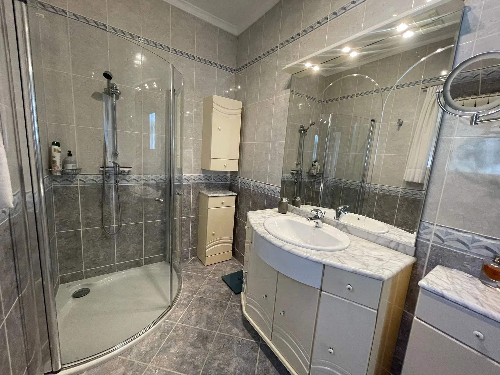 Bathroom with walk-in shower and fitted vanity inside a villa in Calpe.