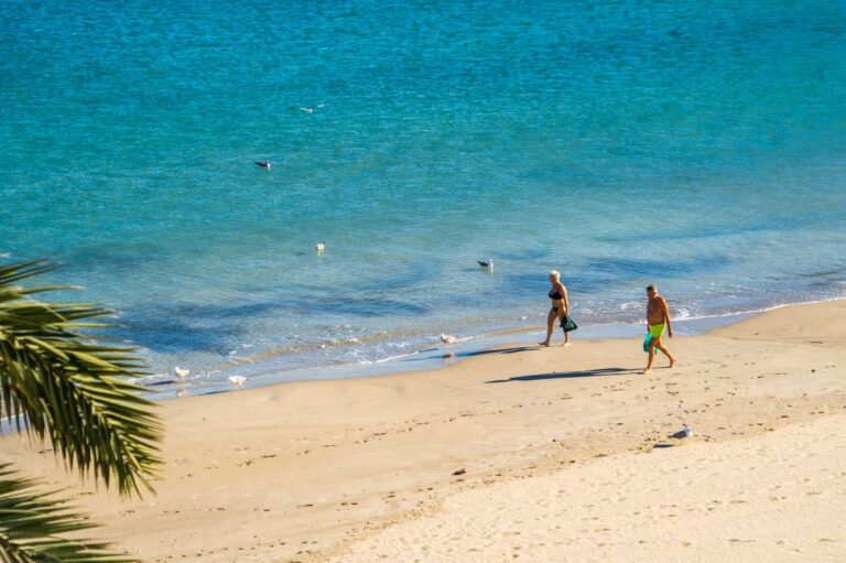 Beach and sea views from a beachfront apartment by La Fossa Beach in Calpe with people walking along the sand and clear Mediterranean water
