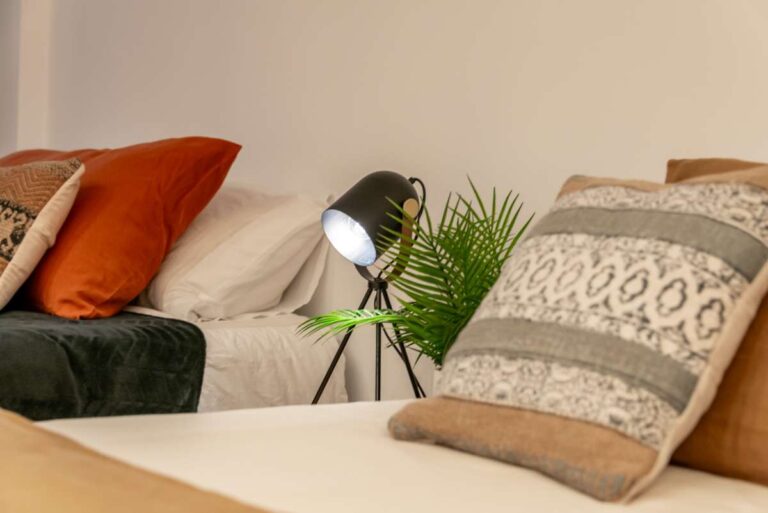 Bedroom detail inside a luxury frontline beach duplex in Mascarat, Altea showing layered cushions, bedside lighting and modern bedding