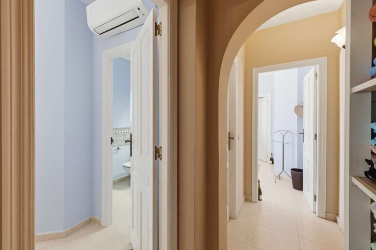 Bedroom hallway inside an elegant Mediterranean villa in Altea Hills with en-suite access, arched doorway and bright interior finish