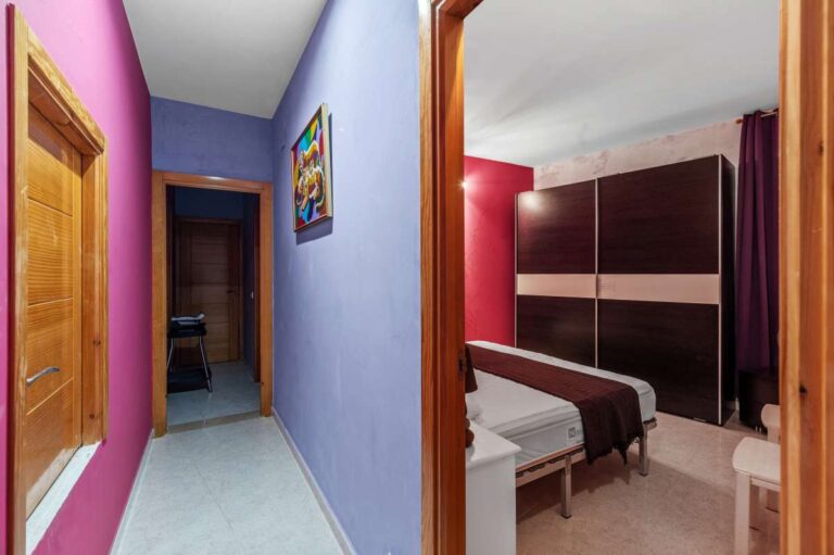 Bedroom hallway inside an independent apartment of a Benissa sea view villa with bright walls, wooden doors and bedroom access