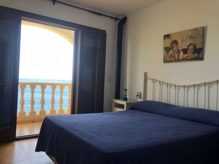 Bedroom inside a frontline townhouse in Calpe with balcony access and sea views