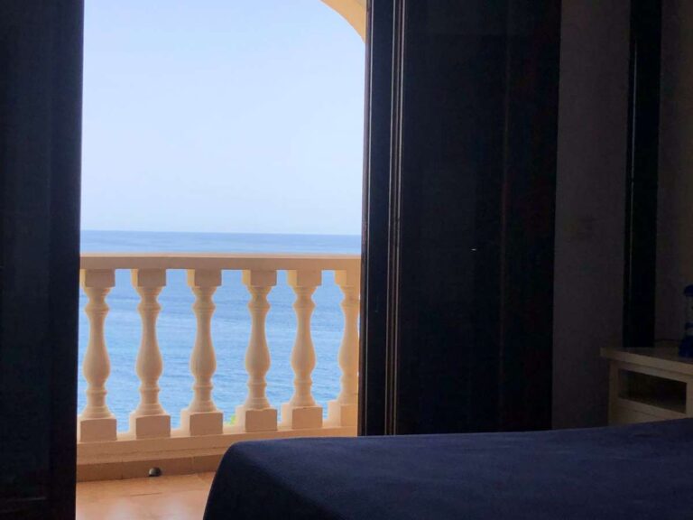 Bedroom inside a frontline townhouse in Calpe with balcony access and views across the Mediterranean Sea