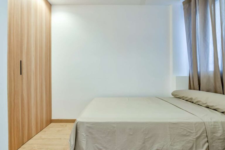 Bedroom inside a luxury frontline beach duplex in Mascarat, Altea with fitted wardrobe, double bed, curtains and wood-effect flooring
