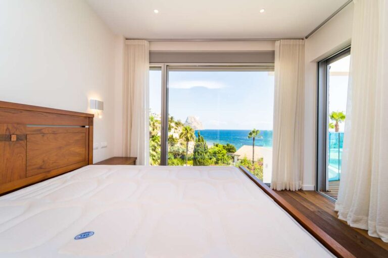 Bedroom inside a luxury villa in Calpe with terrace access, sea views, wood flooring and natural light