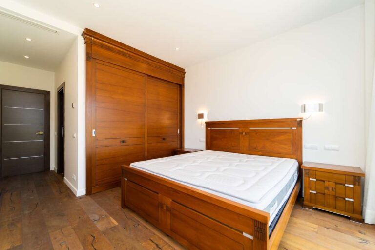 Bedroom inside a luxury villa in Calpe with wood flooring, fitted wardrobes, matching wood furniture and bright interior finish