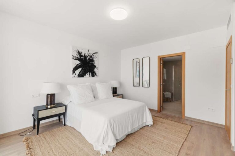 Bedroom inside a modern villa in Altea Hills with en-suite access, neutral interior, bedside tables and bright modern finish