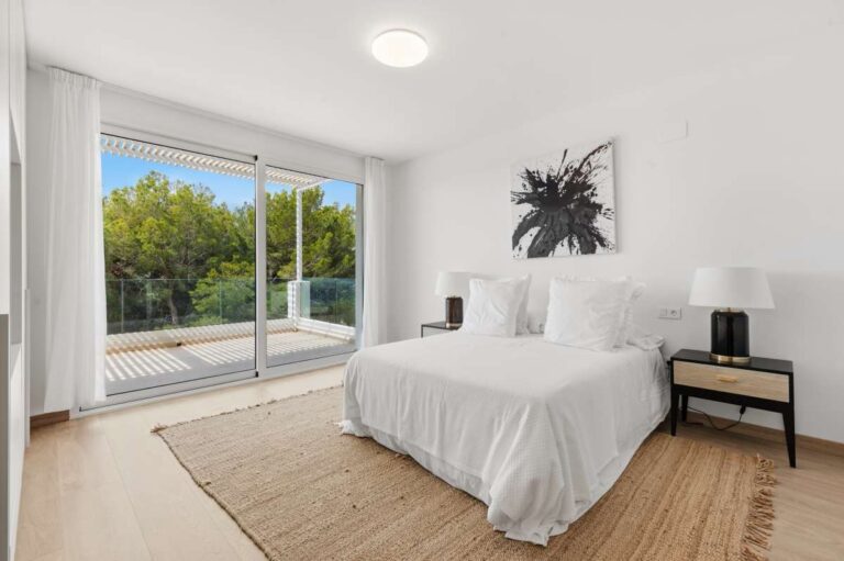 Bedroom inside a modern villa in Altea Hills with terrace access, garden views, neutral interior and bright modern finish