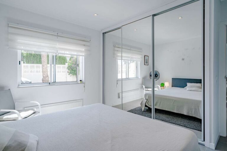 Bedroom inside a modern villa in Calpe with fitted wardrobes, mirrored doors and natural light