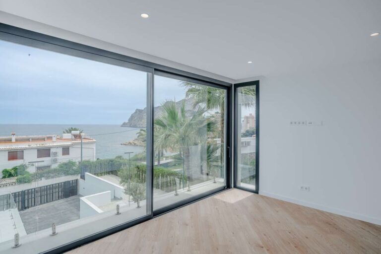 Bedroom inside a modern villa in La Calalga, Calpe with large sliding windows, sea views and natural light