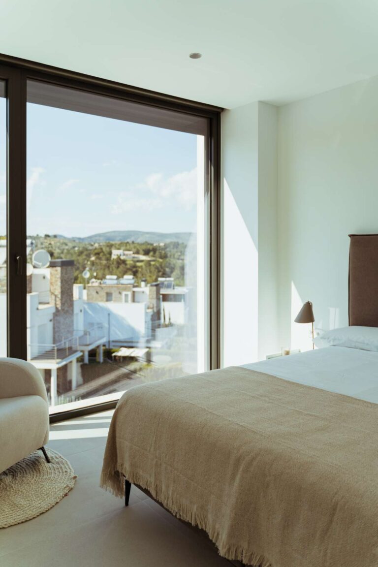 Bedroom inside a new-build luxury villa in Moraira with terrace access, large sliding doors and open views across the surrounding area