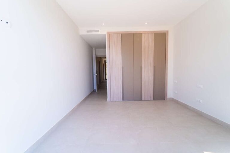 Schlafzimmer in einer neu gebauten Luxusvilla in der Nähe des Yachthafens Puerto Blanco in Calpe mit Einbauschränken, hellem Interieur und moderner, neutraler Farbgestaltung