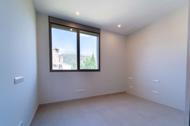Schlafzimmer in einer neu gebauten Luxusvilla in der Nähe des Yachthafens Puerto Blanco in Calpe mit großem Fenster, neutraler Inneneinrichtung und modernem, hellem Finish
