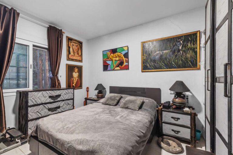 Bedroom inside a panoramic sea view villa in Benissa with double bed, window, wall art and traditional interior details