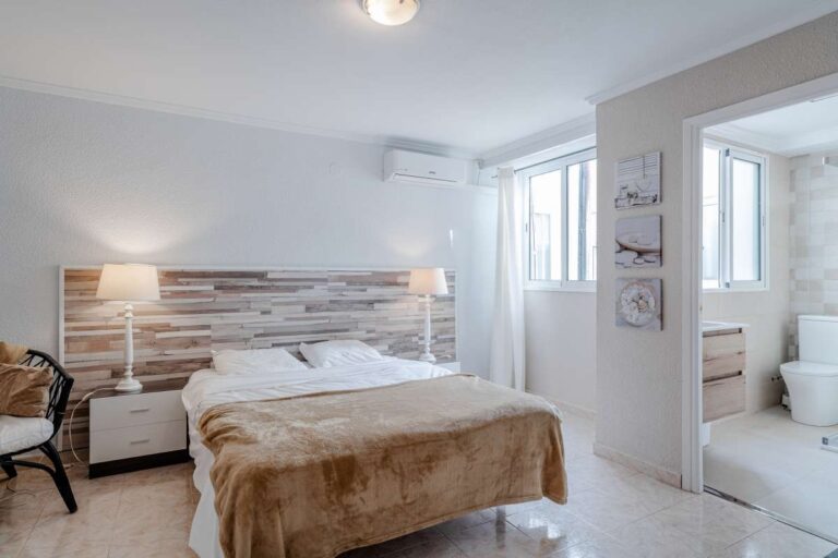 Bedroom inside a renovated apartment by La Fossa Beach in Calpe with en-suite access, bright interior finish and neutral bedroom styling