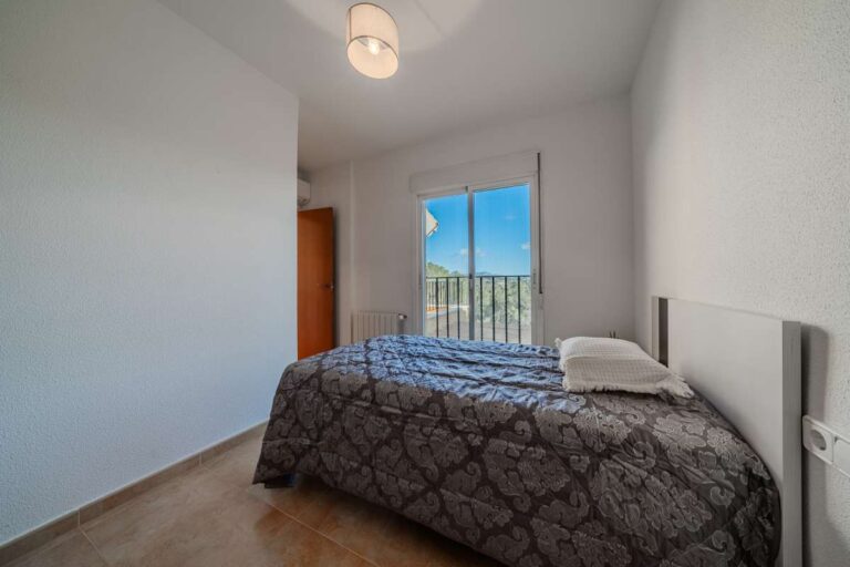 Bedroom inside a semi-detached house in Calpe with balcony access, natural light and mountain views