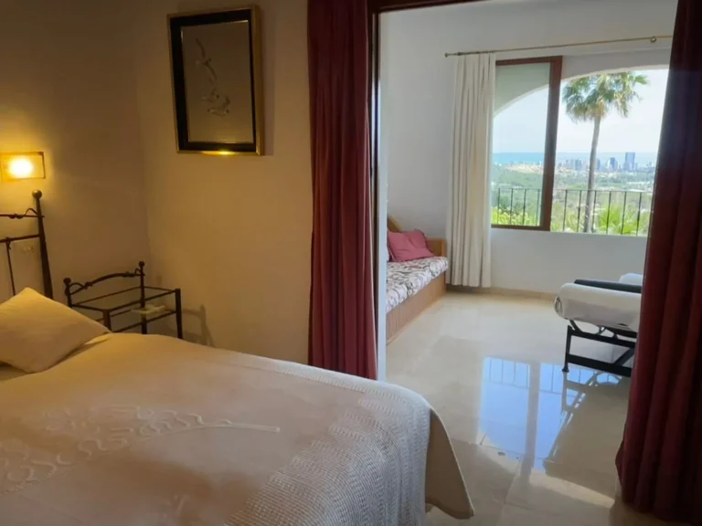 Bedroom leading into a lounge area with sea views inside a villa in Calpe.