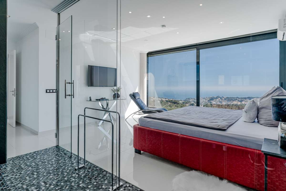 Bedroom suite with en-suite bathroom, red bed and panoramic sea views inside a luxury villa in Gran Sol, Calpe.