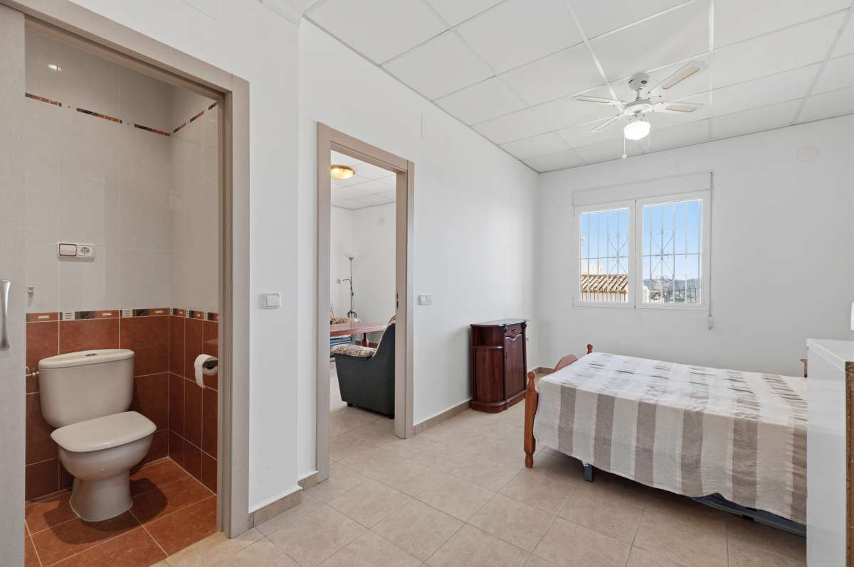Bedroom with direct bathroom access and natural light inside a villa in Calpe.