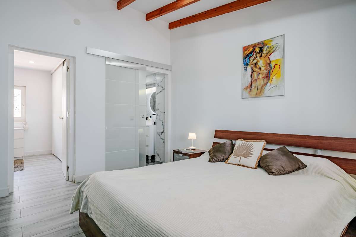 Bedroom with en-suite bathroom access and light modern interior inside a renovated Mediterranean villa in La Cometa, Calpe.