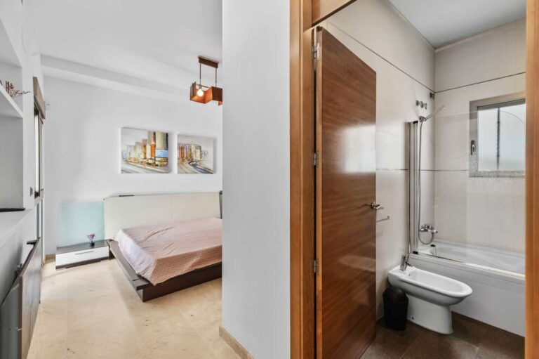 Bedroom with en-suite bathroom and natural light inside a modern spacious villa in Calpe.