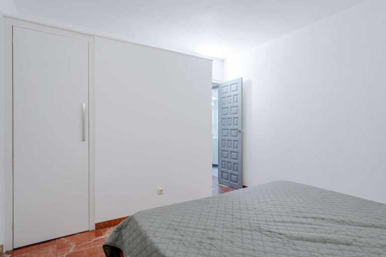 Bedroom with fitted wardrobe and terracotta flooring inside a Mediterranean villa in Maryvilla, Calpe.