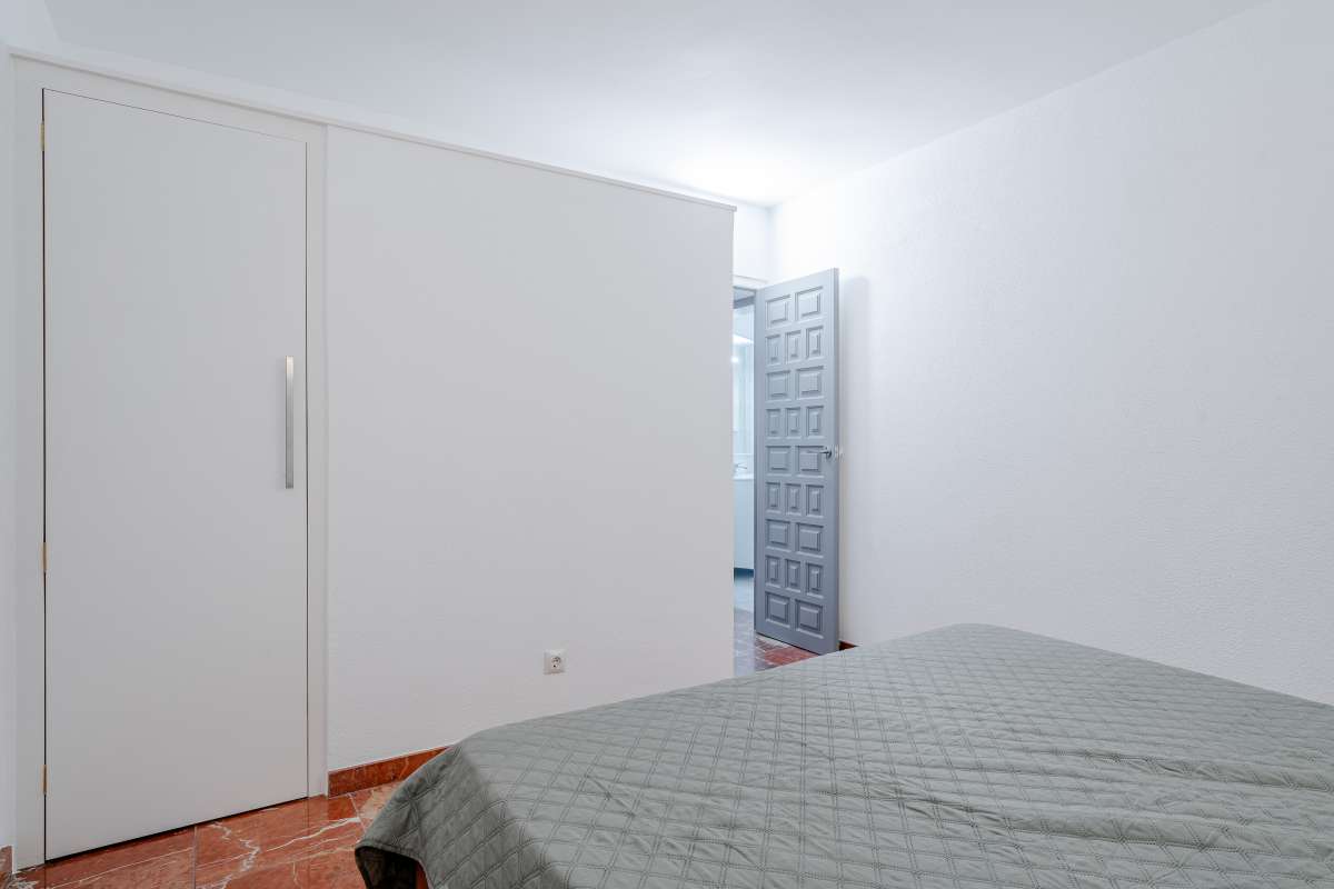 Bedroom with fitted wardrobe and terracotta flooring inside a Mediterranean villa in Maryvilla, Calpe.