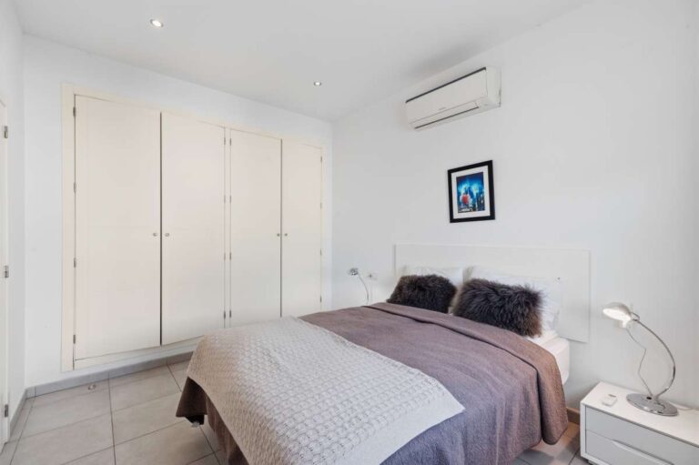 Bedroom with fitted wardrobes, air conditioning, and natural light inside a villa in Calpe.