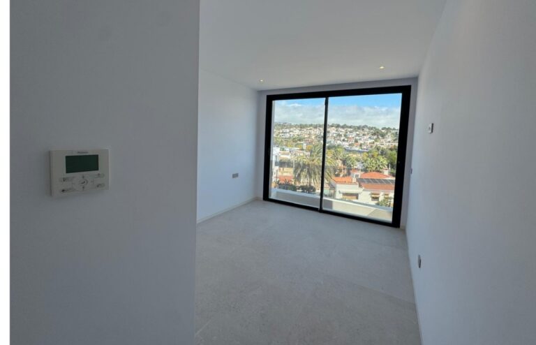 Bedroom with large window at luxury villa near La Fustera Beach