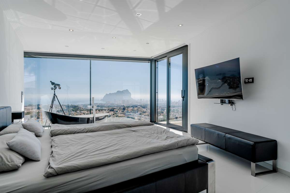 Bedroom with large windows, contemporary finishes and panoramic sea views inside a luxury villa in Gran Sol, Calpe.