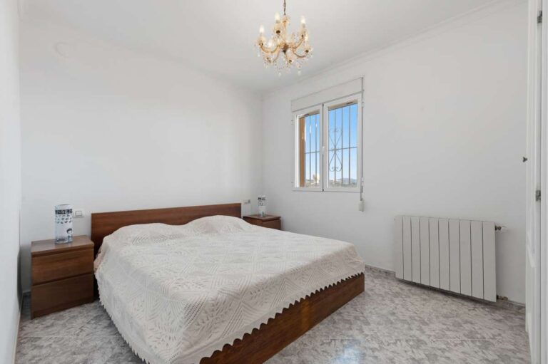 Bedroom with natural light and radiator inside a villa in Calpe.