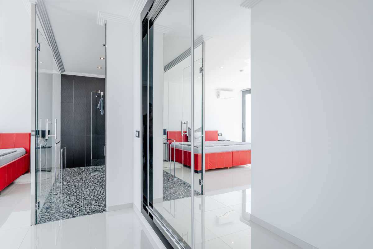 Bedroom with red bed, en-suite bathroom and contemporary finishes inside a luxury villa in Gran Sol, Calpe.
