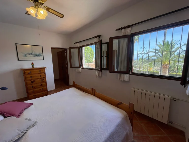 Bedroom with sea views, radiator, and natural light inside a villa in Calpe.