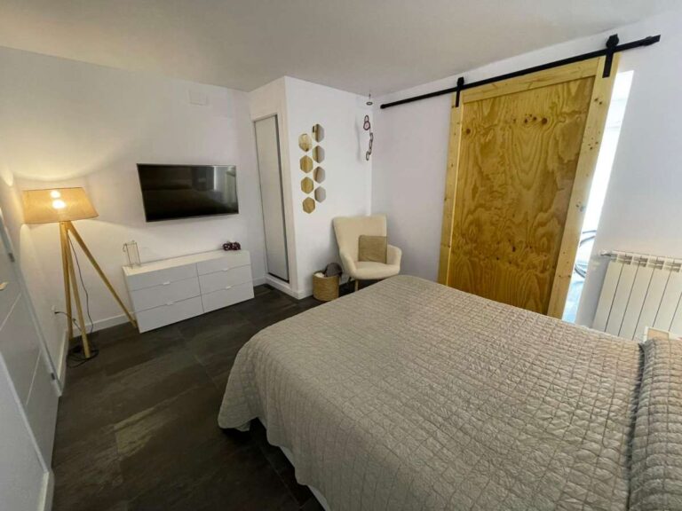 Bedroom with sliding door detail, fitted radiator and natural light inside a refurbished villa in Canuta, Calpe.