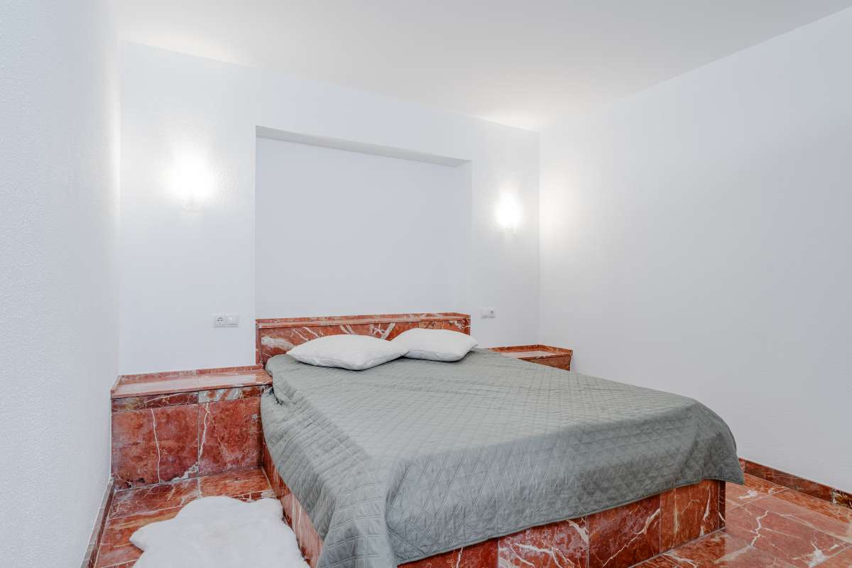 Bedroom with terracotta flooring and white walls inside an independent apartment at a Mediterranean villa in Maryvilla, Calpe.