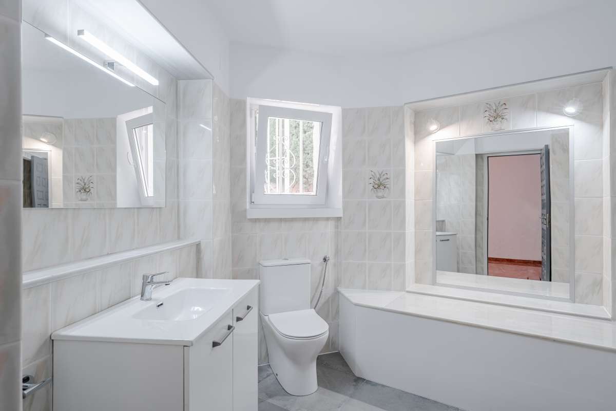 Bright bathroom with bath, toilet and vanity inside a Mediterranean villa in Maryvilla, Calpe.