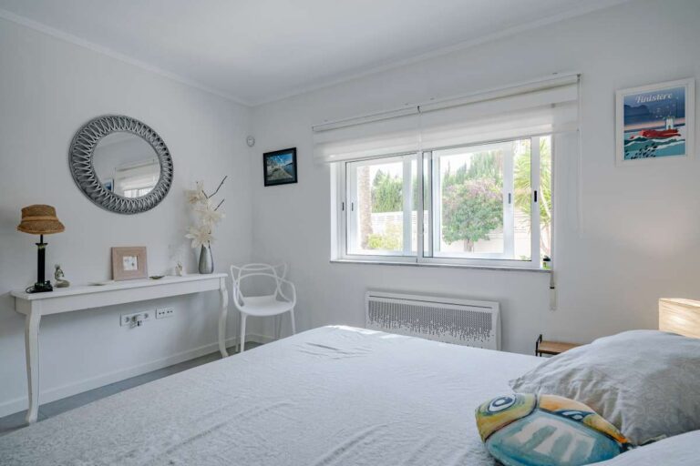 Bright bedroom inside a modern villa in Calpe with large window, white interiors and natural light