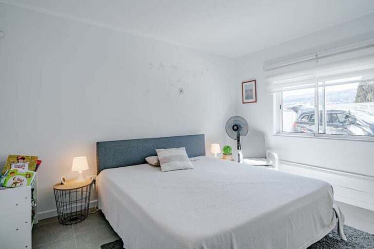 Bright bedroom inside a villa for sale in Calpe with large window, bedside tables and natural light