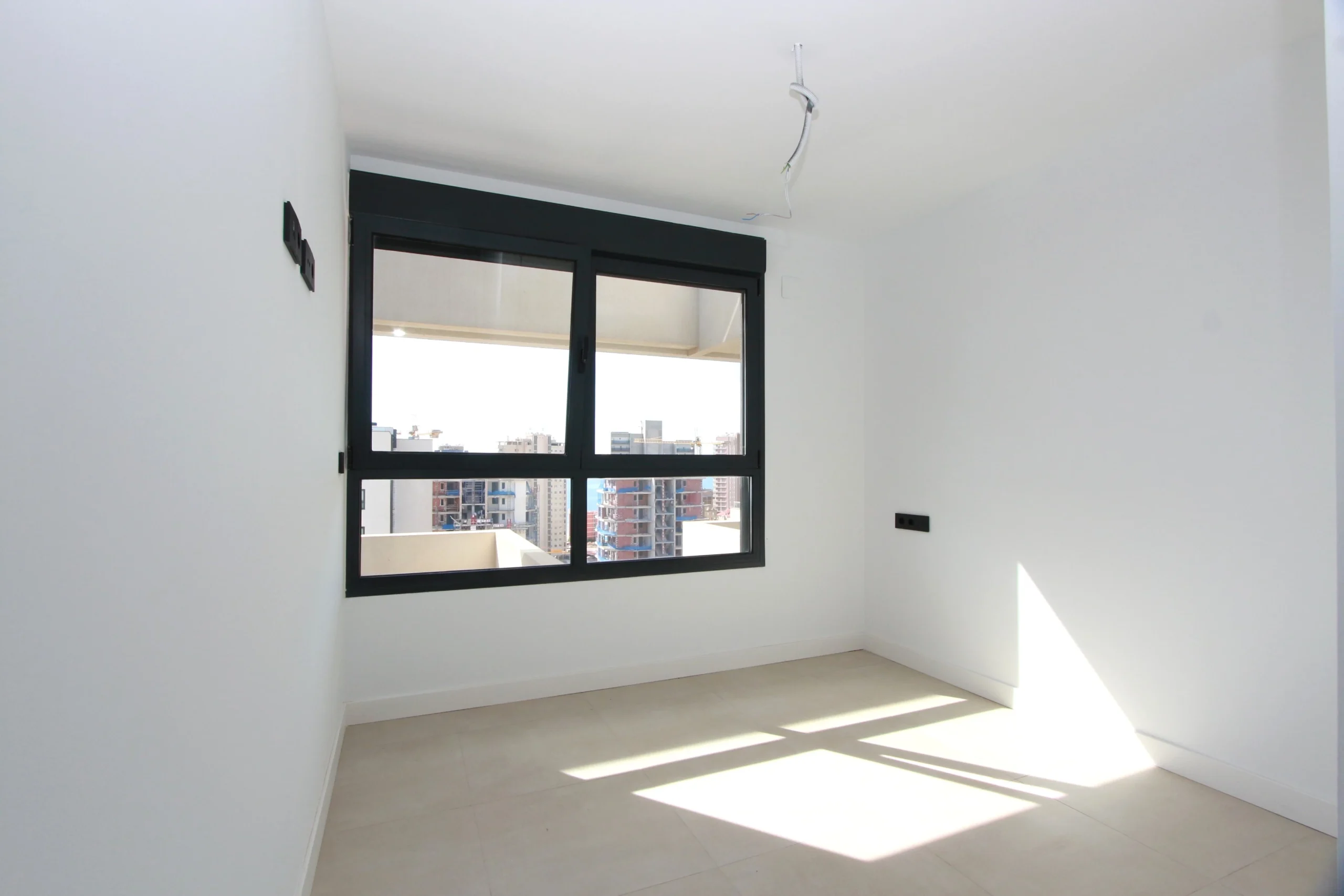 Bright bedroom with large window inside modern penthouse in Calpe