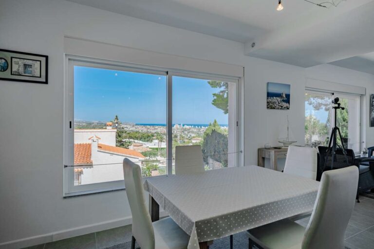 Bright dining area inside a modern villa in Calpe with large window and open views across the surrounding area
